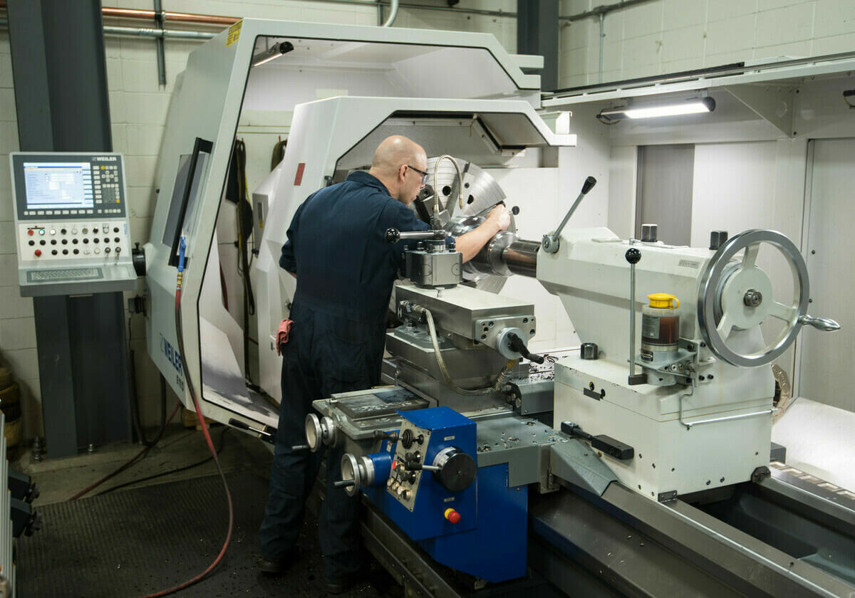 Image of an Argus employee working on a CNC machine.